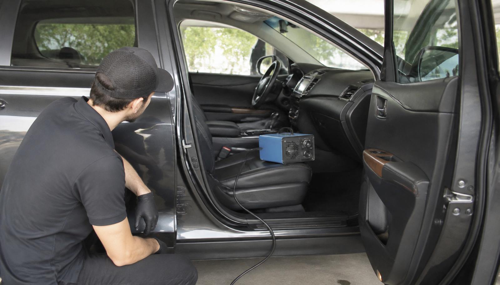 Ozone generator running on the passenger seat of an SUV during interior odour treatment
