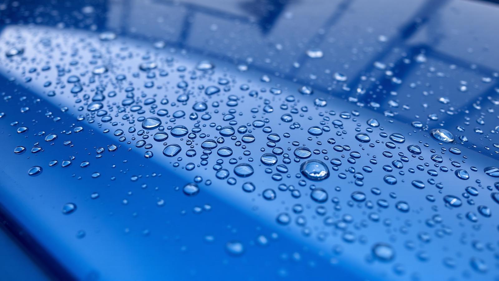 Tight round water beads on a freshly protected midnight blue car bonnet