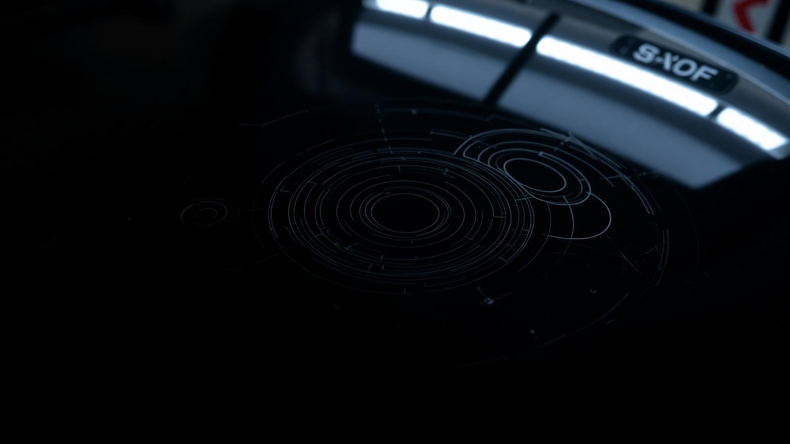 Fine circular swirl marks and holograms on black car paint highlighted by a work lamp